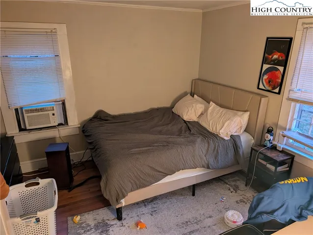 a bedroom with a bed and wooden floor