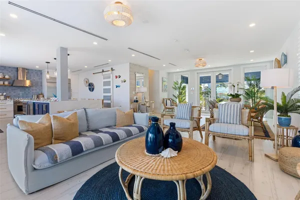 a kitchen with stainless steel appliances kitchen island granite countertop a table chairs sink and cabinets