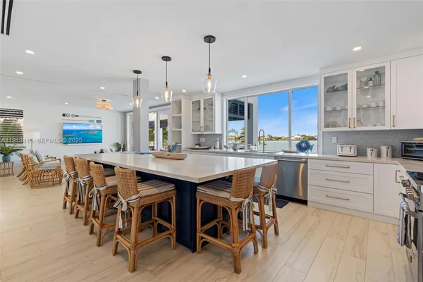a living room with furniture a flat screen tv and floor to ceiling window
