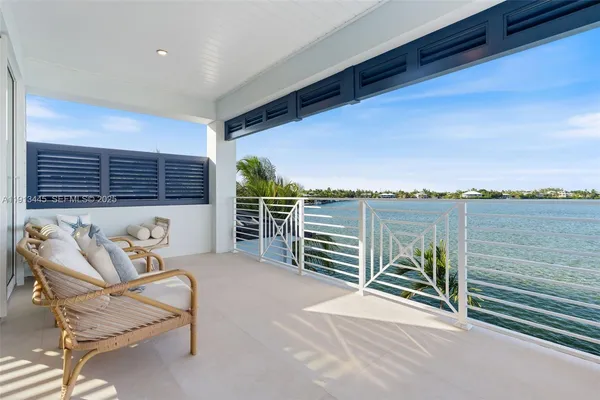 a living room with furniture kitchen view and large windows