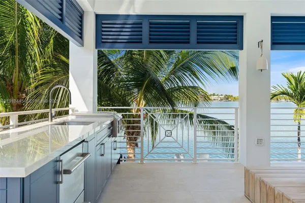 a view of a patio with table and chairs potted plants and palm tree