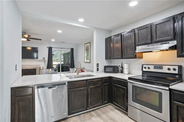 a kitchen with stainless steel appliances granite countertop a sink stove and microwave