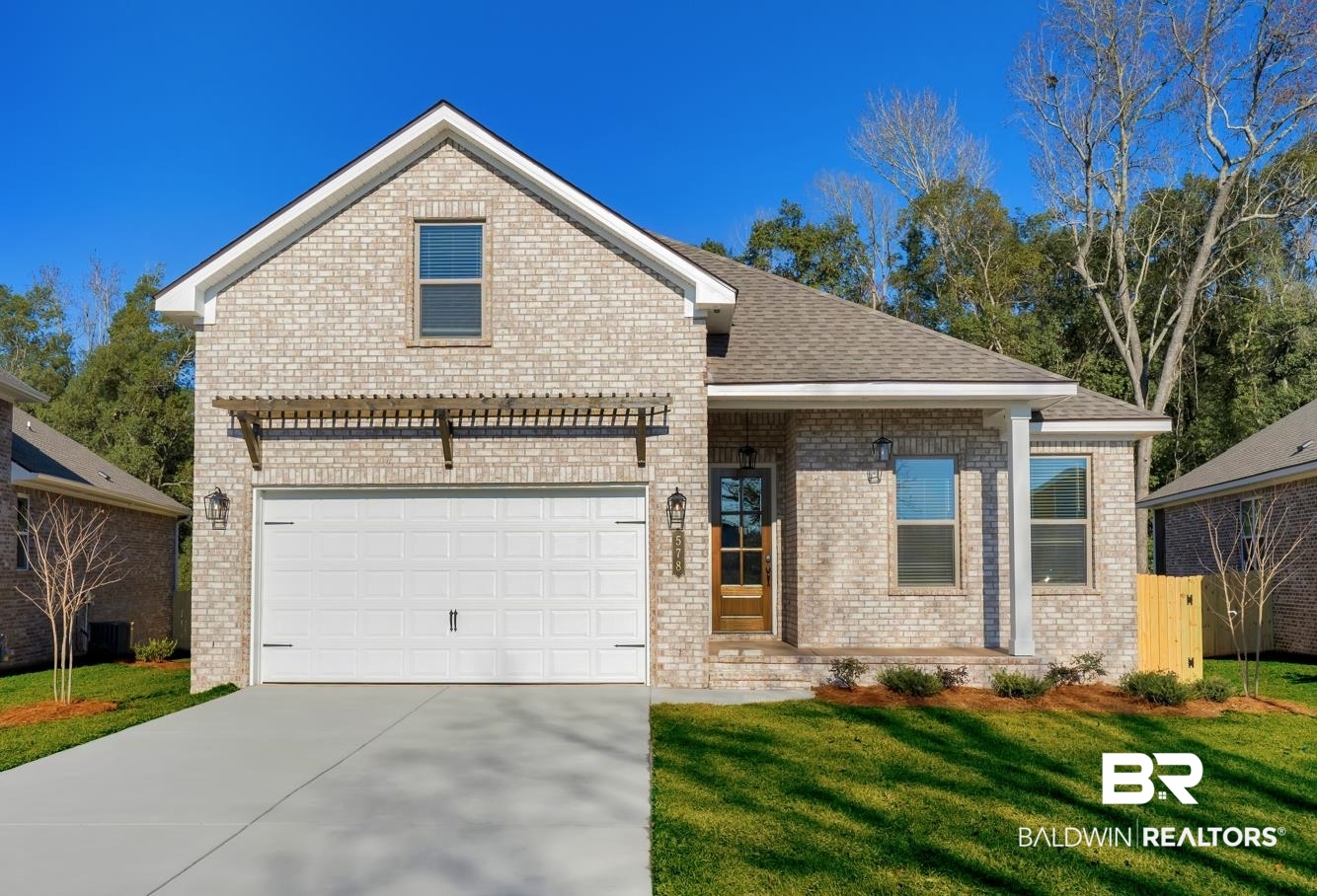 571 Morning Mist Way Fairhope, AL 36532 - Photo 1 of 47 View of front facade featuring brick siding, concrete driveway, a garage, a front yard, and roof with shingles
