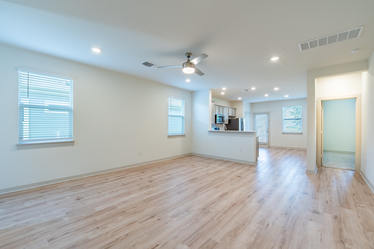 10801 Meris Lane Austin, TX 78754 - Photo 3 of 18 Natural wood flooring complements this open-concept living area and kitchen, ideal for relaxed entertaining.