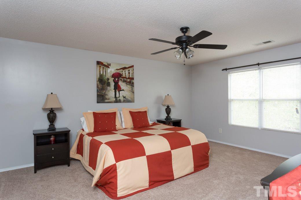 3169 Varcroft Road Knightdale, NC 27545 - Photo 5 of 9 a bedroom with a bed and a chandelier