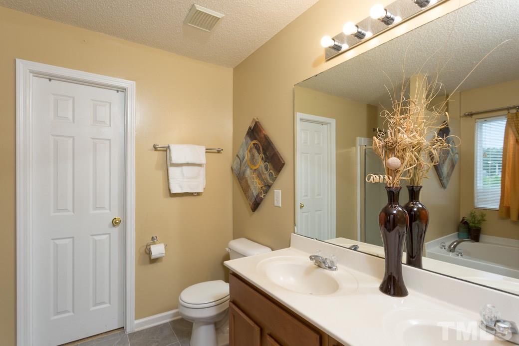 3169 Varcroft Road Knightdale, NC 27545 - Photo 6 of 9 a bathroom with a sink vanity granite toilet and a mirror