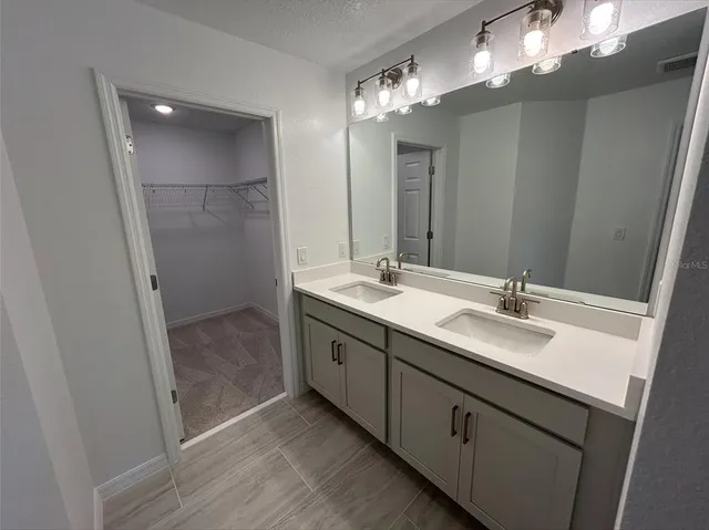a bathroom with a double vanity sink and a mirror