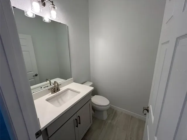 a bathroom with a sink vanity and toilet