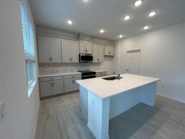 a kitchen with a sink a stove a microwave and cabinets