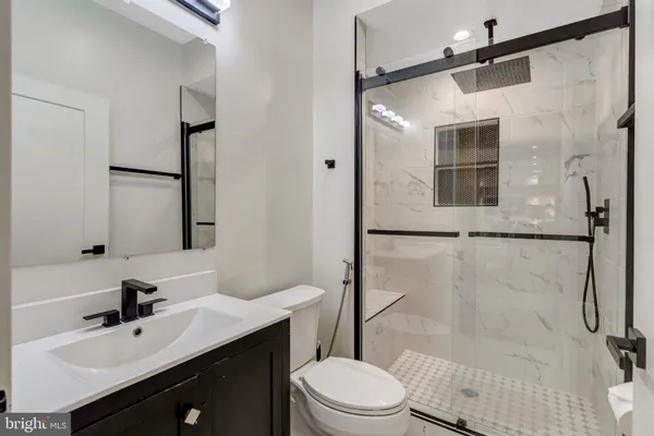 a bathroom with a sink mirror toilet and shower