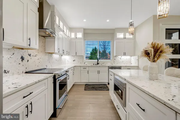 a kitchen with granite countertop a sink stainless steel appliances and cabinets