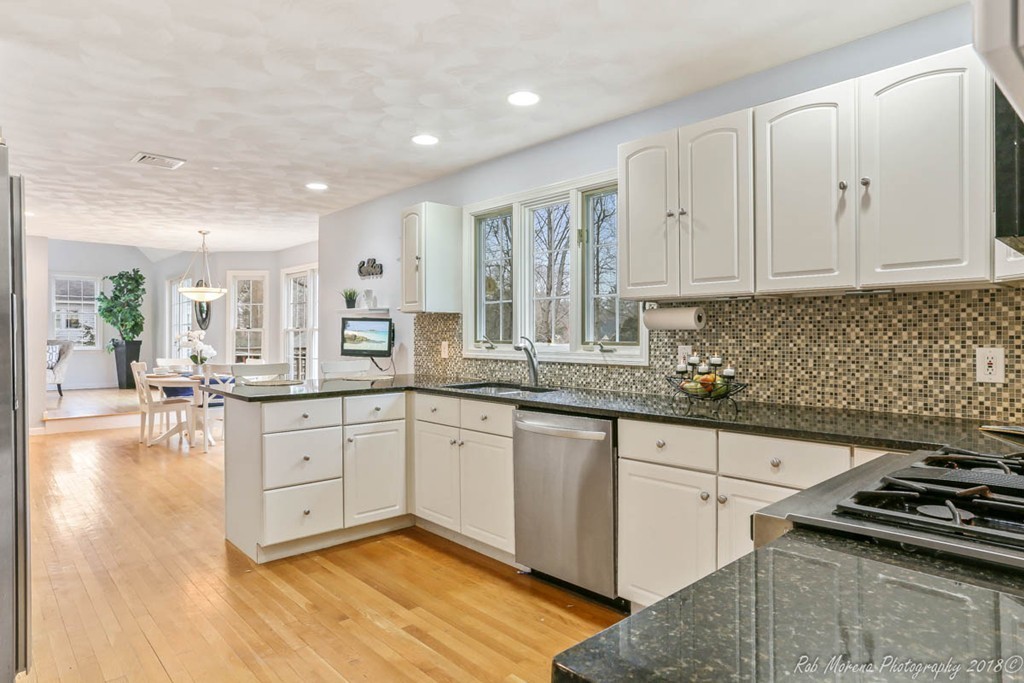295 South Main Street Andover, MA 01810 - Photo 15 of 30 a kitchen with granite countertop a stove a sink and white cabinets