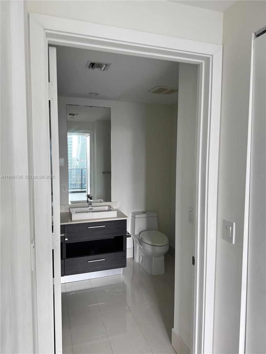 45 Southwest 9th Street, Unit 3404 Miami, FL 33130 - Photo 11 of 25 a bathroom with a sink a toilet and a mirror