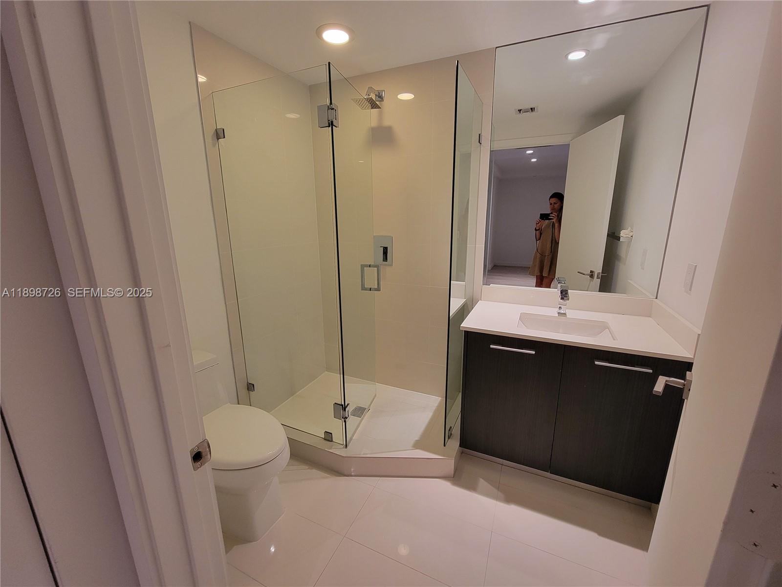 45 Southwest 9th Street, Unit 3404 Miami, FL 33130 - Photo 3 of 25 a bathroom with a double vanity sink toilet and shower