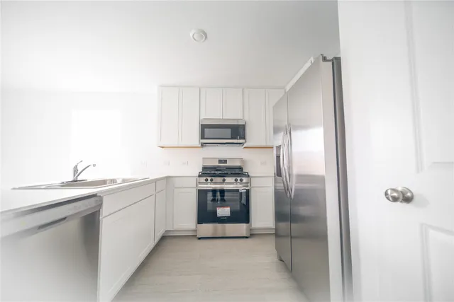 a kitchen with a sink and stainless steel appliances