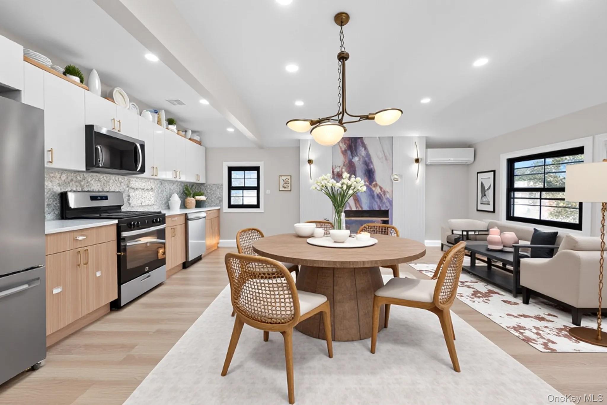 115-16 199th Street Queens, NY 11412 - Photo 10 of 21 Kitchen with appliances with stainless steel finishes, light countertops, decorative light fixtures, white cabinetry, and modern cabinets