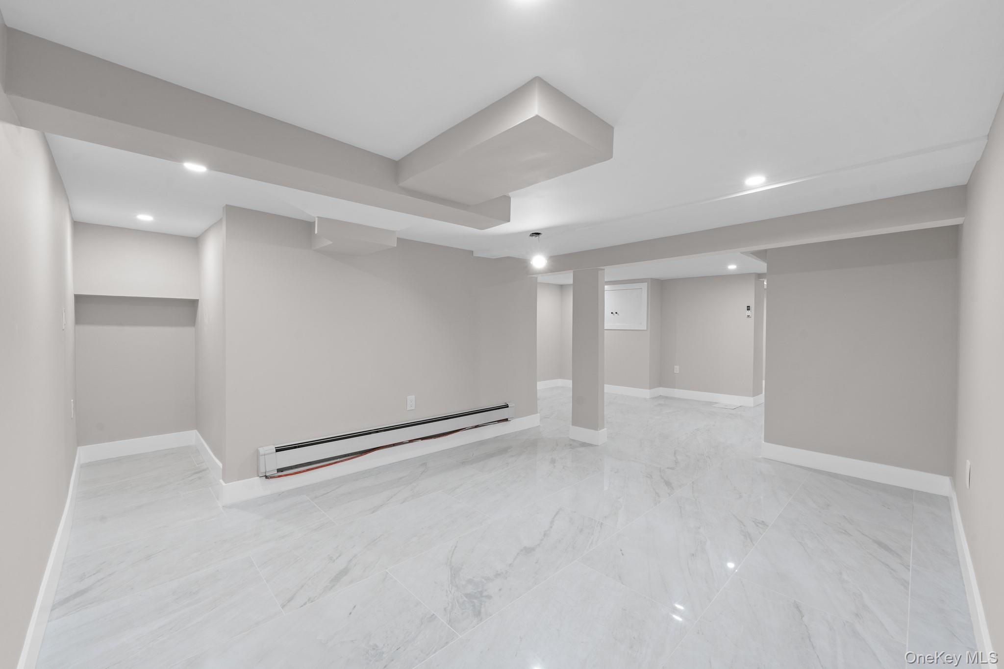 115-16 199th Street Queens, NY 11412 - Photo 16 of 21 Finished basement featuring recessed lighting, a baseboard radiator, and light marble finish floors