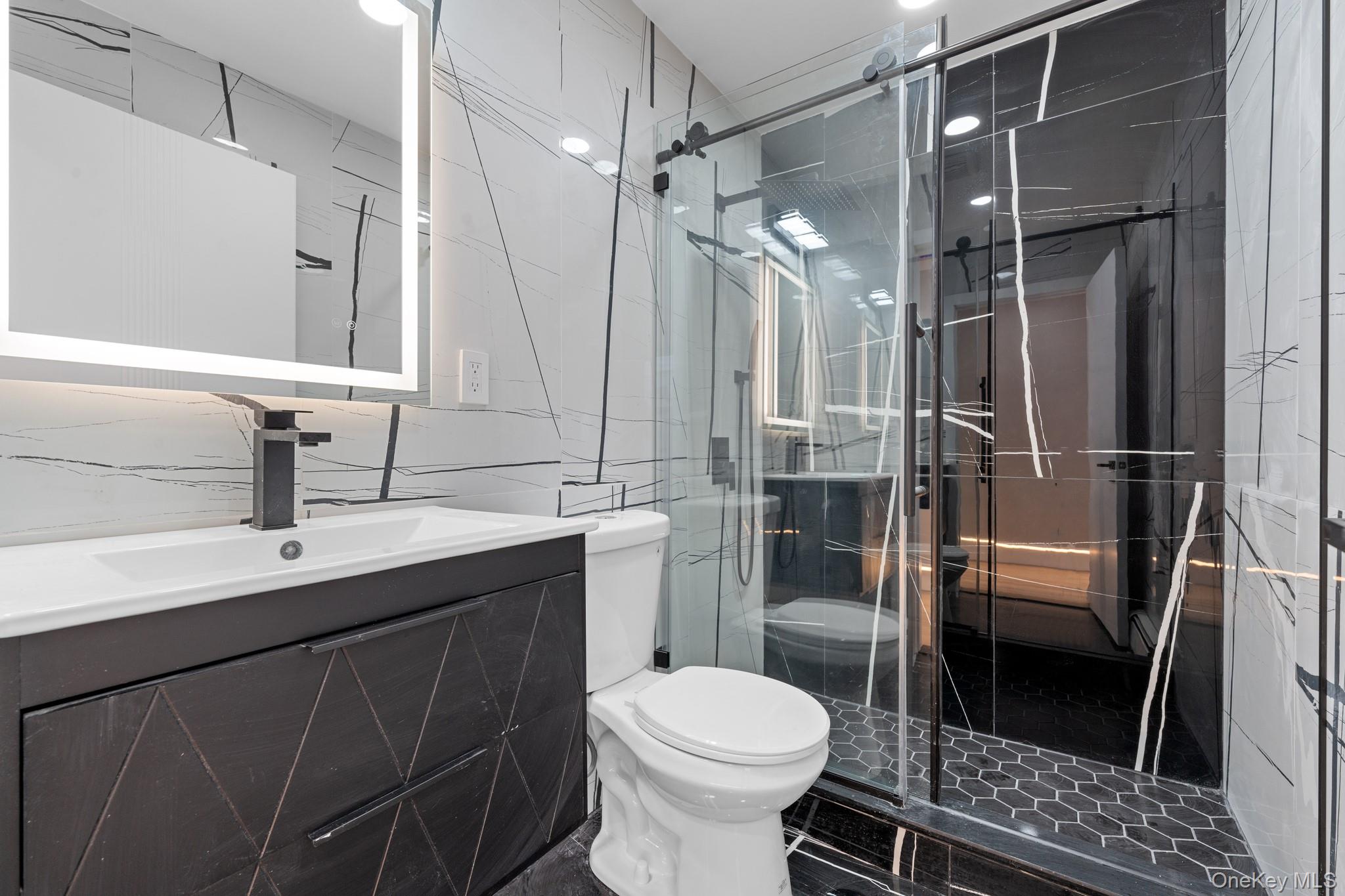 115-16 199th Street Queens, NY 11412 - Photo 4 of 21 Full bath featuring vanity, tile walls, and a marble finish shower