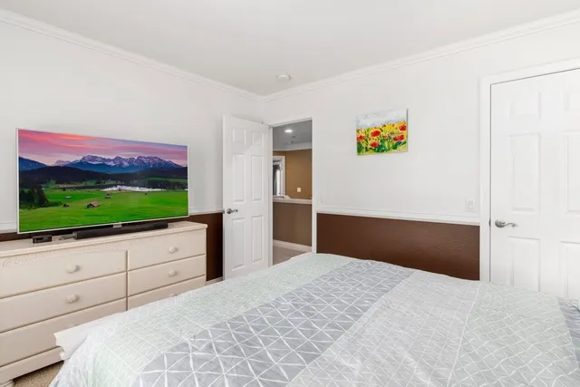 a bedroom with a bed and a flat screen tv