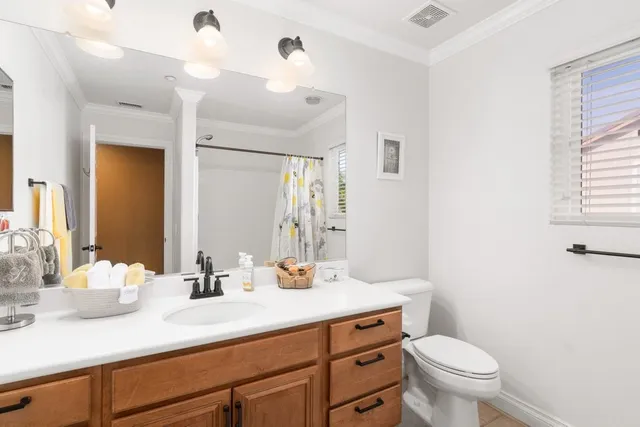 a bathroom with a sink a toilet a mirror and vanity