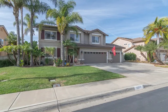 a front view of a house with a yard and a garage