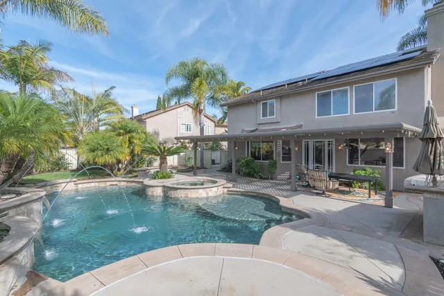 a view of a house with sitting area and swimming pool