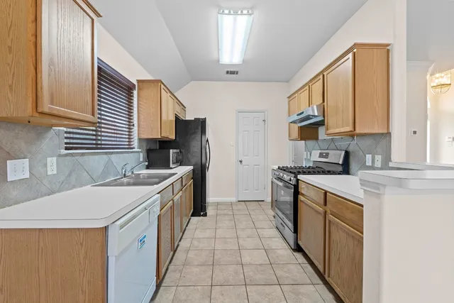a kitchen with a sink stove and cabinets