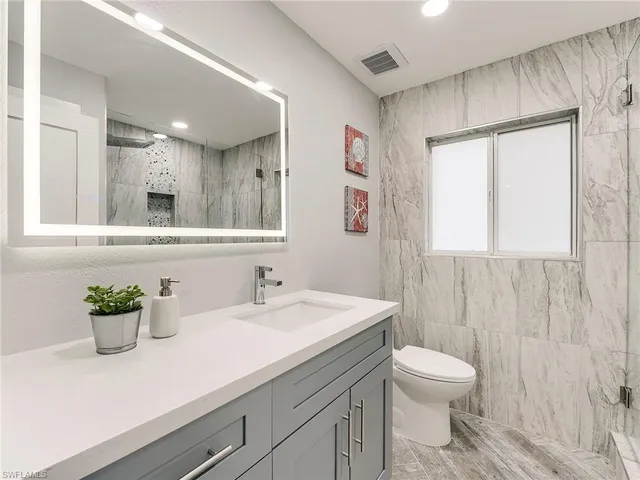 a bathroom with a sink a toilet and mirror