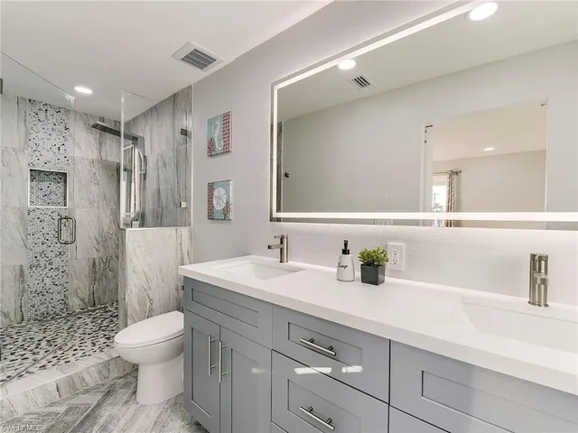 a bathroom with a sink a toilet and shower