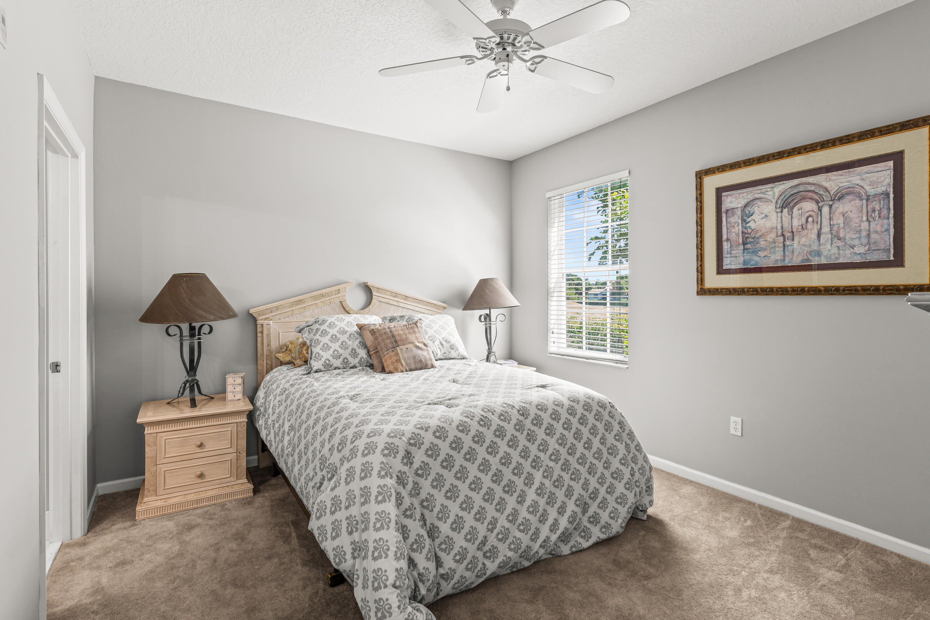1951 Brandywine Road, Unit 59303 West Palm Beach, FL 33409 - Photo 12 of 25 a bedroom with a bed and a painting on the wall
