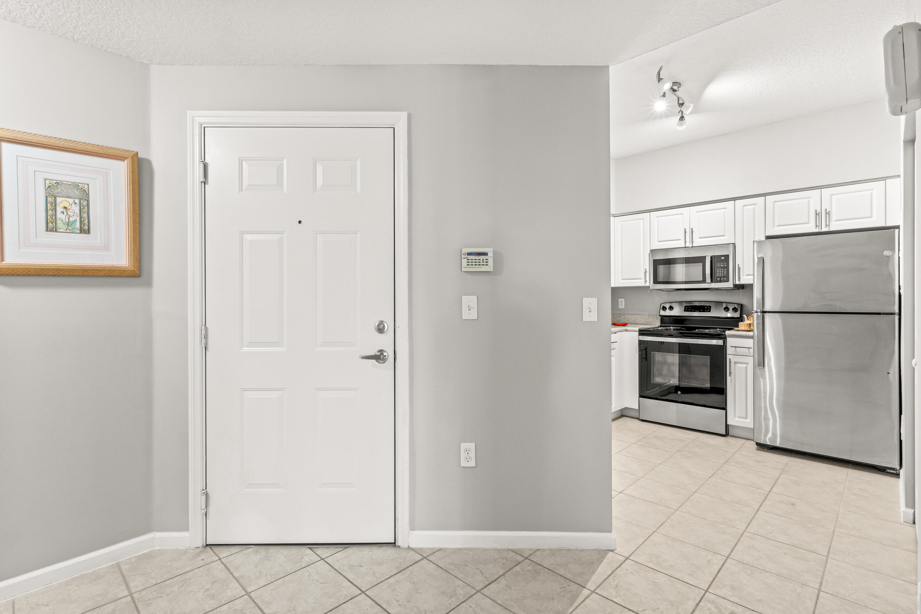 a kitchen with granite countertop a refrigerator and a stove top oven