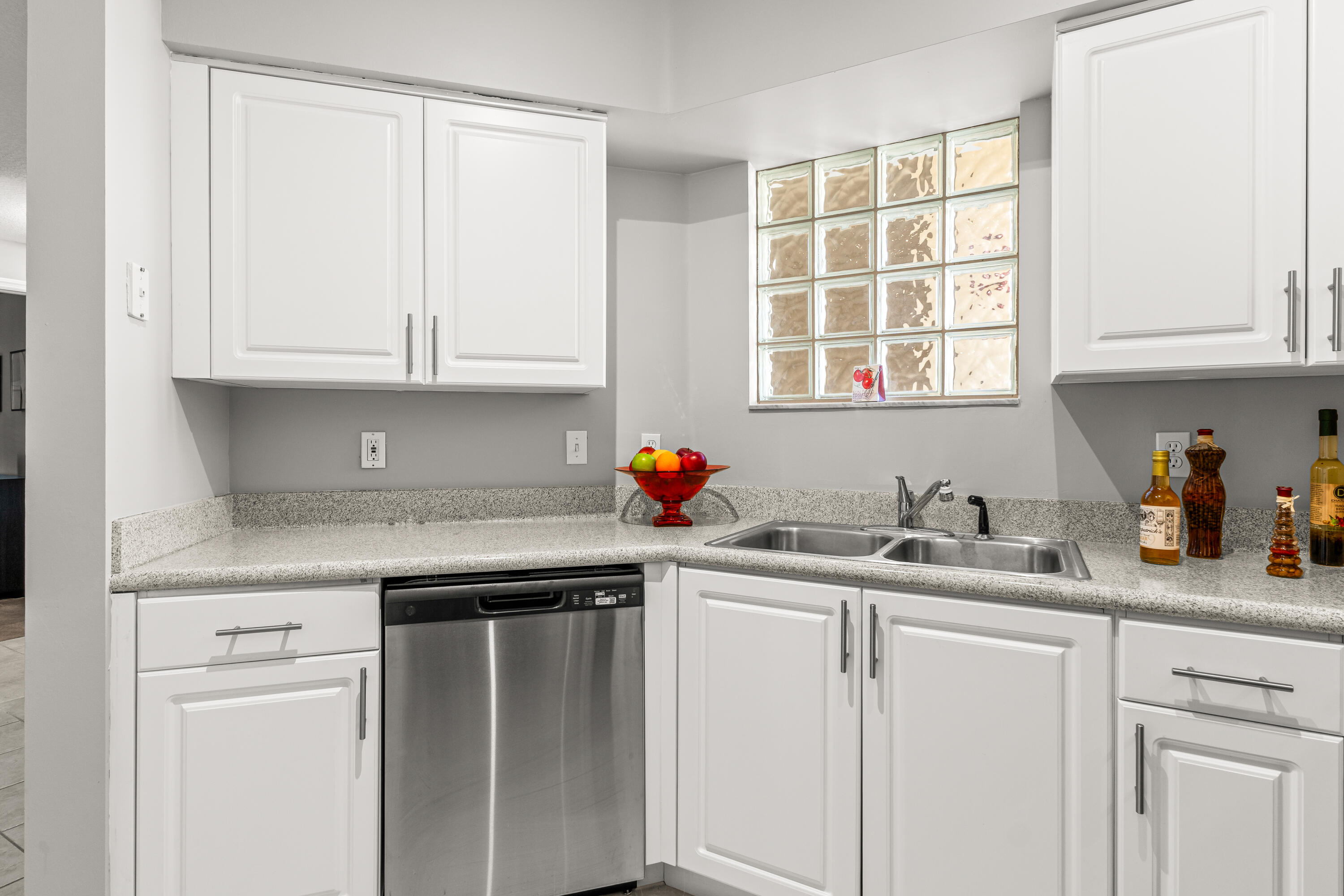 1951 Brandywine Road, Unit 59303 West Palm Beach, FL 33409 - Photo 3 of 25 a kitchen with stainless steel appliances granite countertop a sink dishwasher window and cabinets