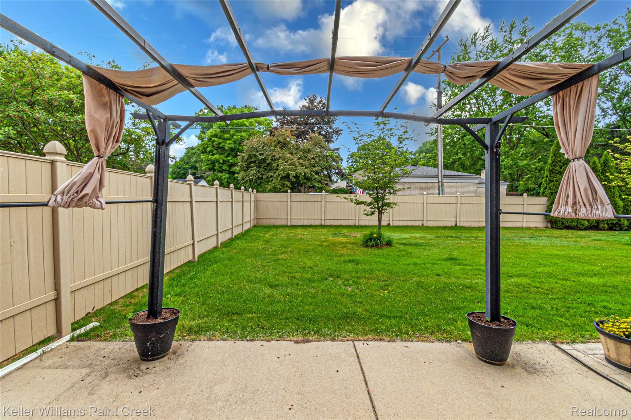 11401 Messmore Road Utica, MI 48317 - Photo 31 of 43 Backyard featuring a metal pergola with fabric accents, concrete patio, expansive lawn, and light-toned fencing
