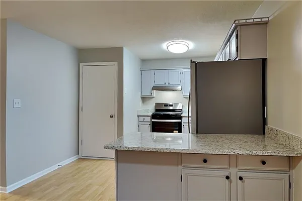 a kitchen with stainless steel appliances granite countertop a refrigerator a stove and a sink