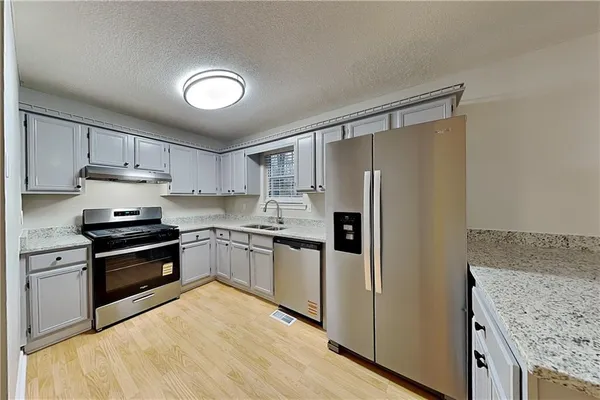 a kitchen with granite countertop stainless steel appliances and wooden cabinets