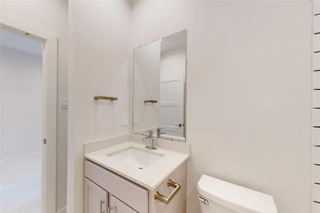 a bathroom with a sink toilet and a mirror