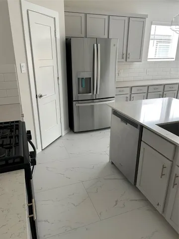 a kitchen with a refrigerator sink and cabinets