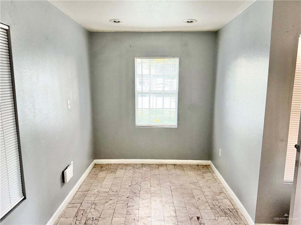204 Ramon Private Road Mission, TX 78572 - Photo 4 of 11 Recessed lighting illuminates this room, featuring textured gray walls, white baseboards, and patterned tile flooring