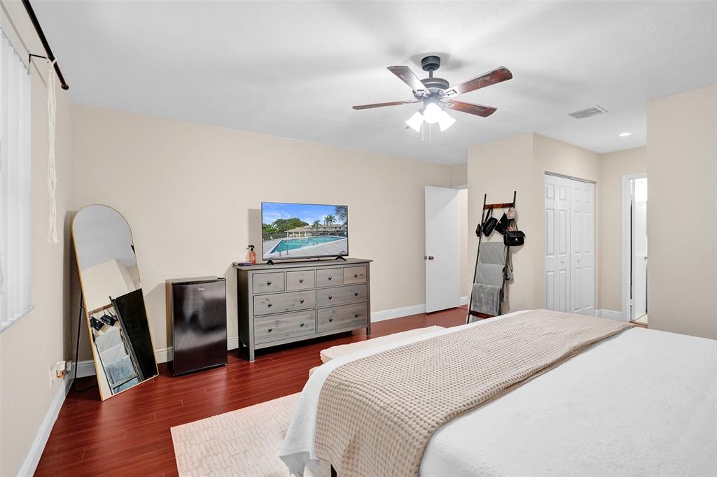 9851 Riverside Drive Coral Springs, FL 33071 - Photo 17 of 35 a bedroom with a bed and a chandelier