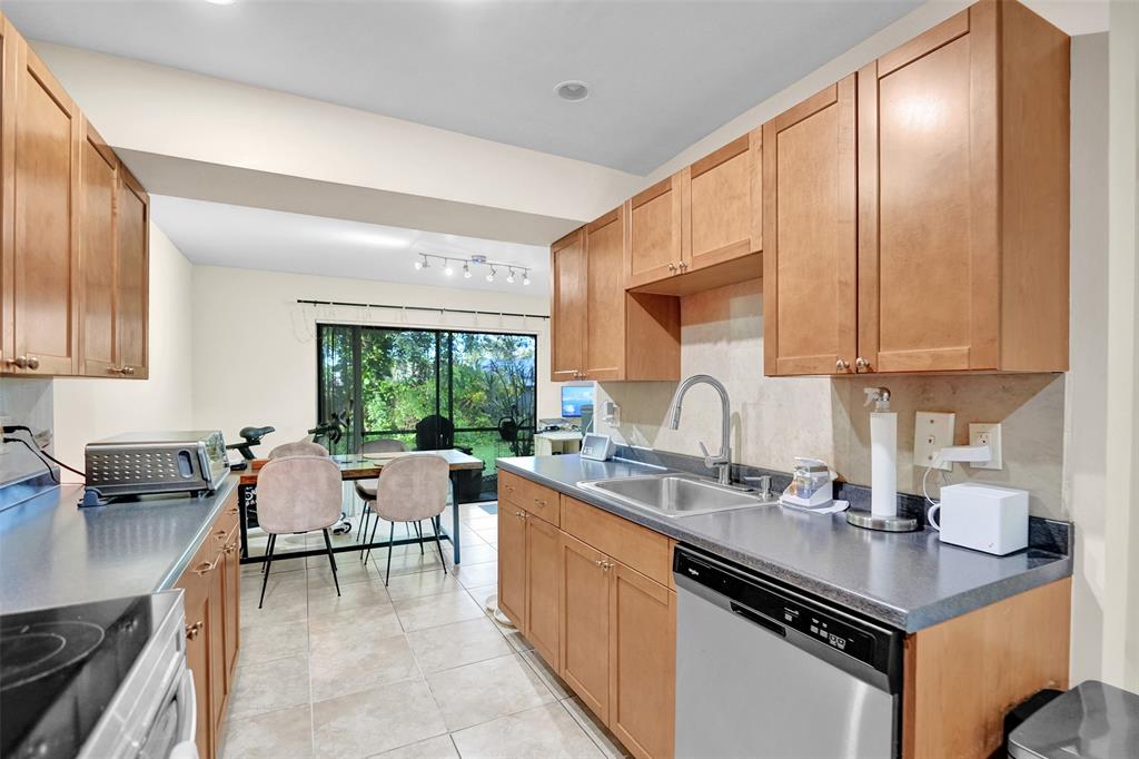 9851 Riverside Drive Coral Springs, FL 33071 - Photo 10 of 35 a kitchen with a stove a sink and cabinets