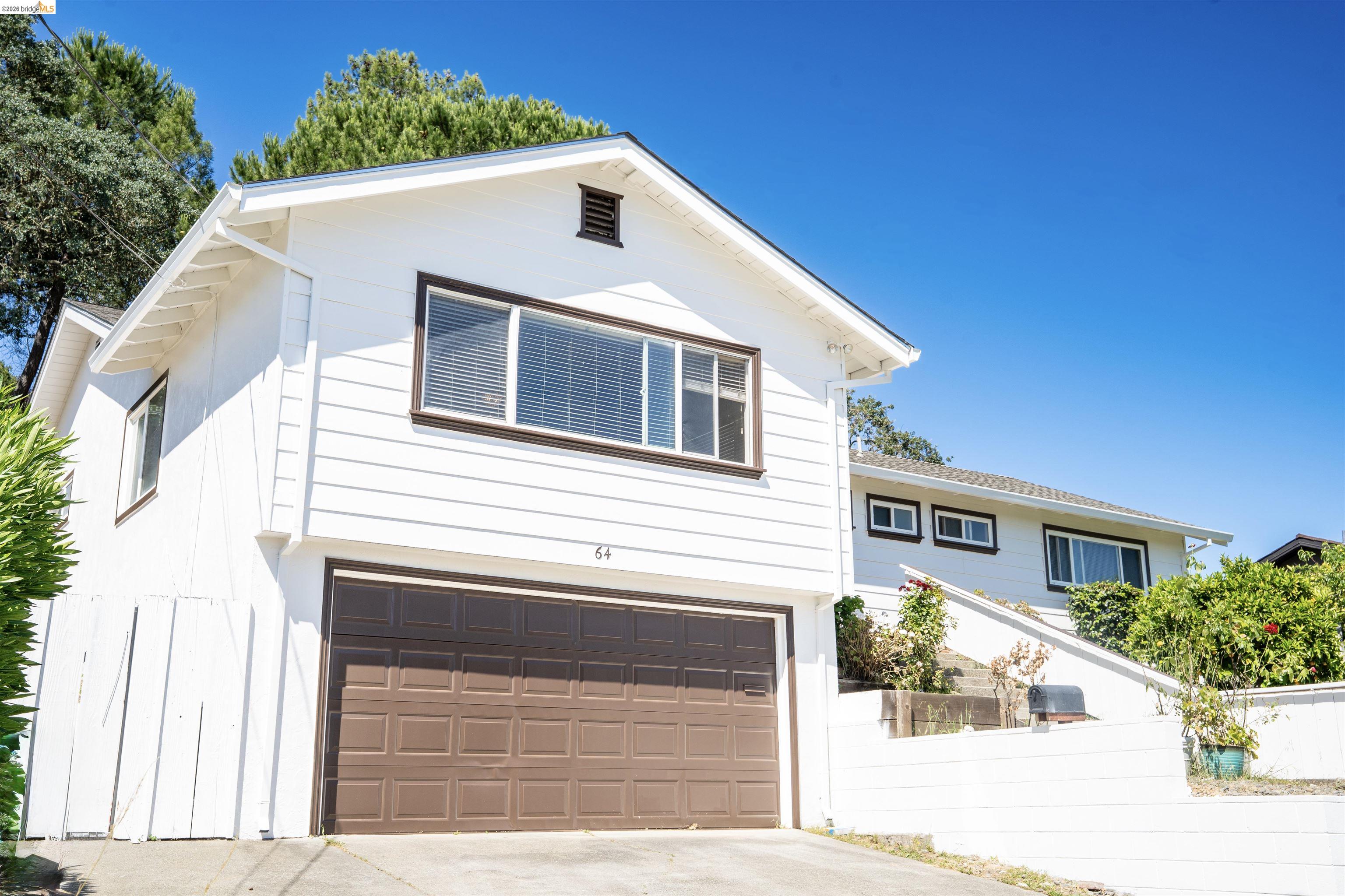 64 Washington Street Novato, CA 94947 - Photo 21 of 21 White exterior with brown trim details, featuring a two-car garage and upper-level window
