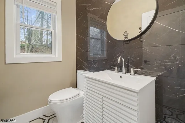 a bathroom with a sink mirror and toilet