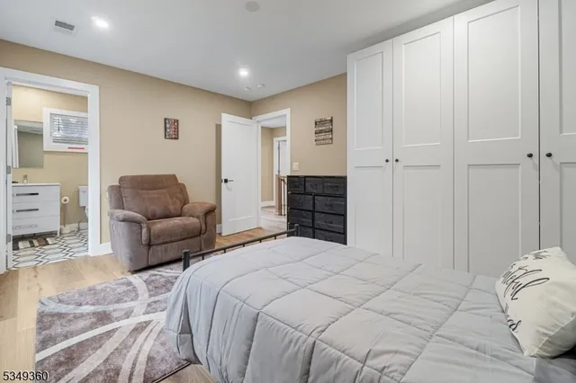 a spacious bedroom with a bed a couch and a view of kitchen