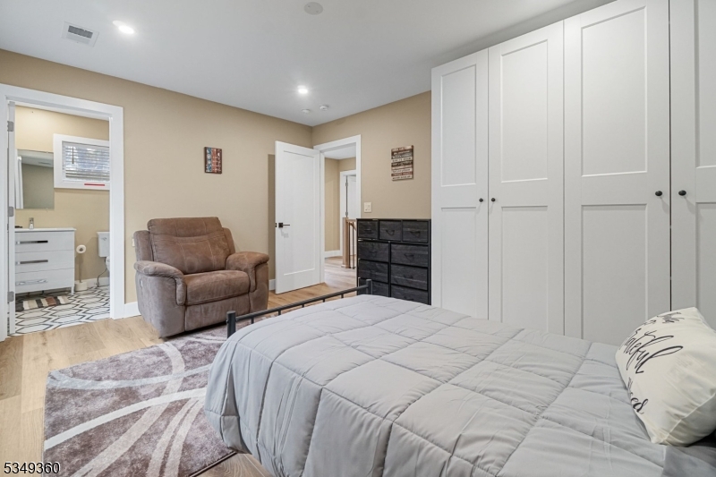 232 Kinnelon Road Kinnelon, NJ 07405 - Photo 18 of 43 a spacious bedroom with a bed a couch and a view of kitchen