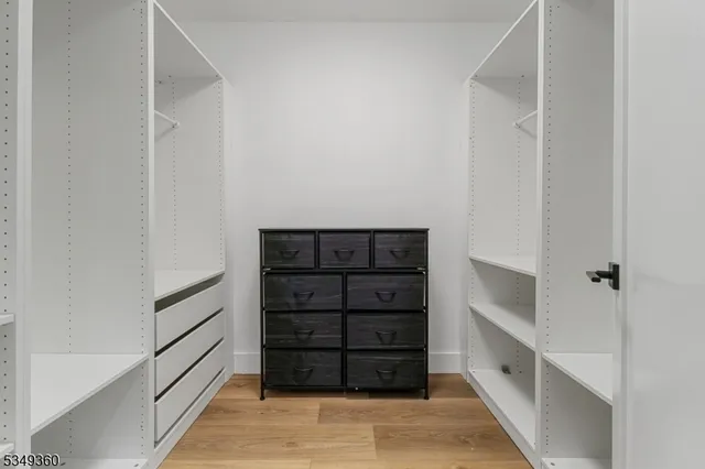 a view of walk in closet with empty racks