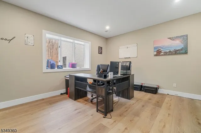a view of a workspace with furniture and a window
