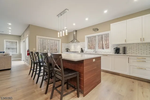 a kitchen with stainless steel appliances kitchen island granite countertop a table chairs sink and cabinets