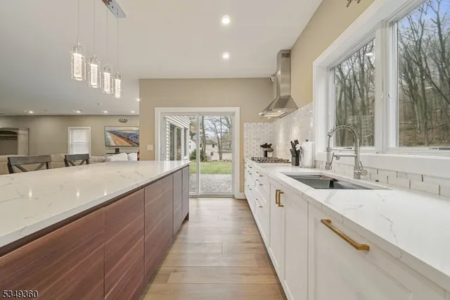 a large kitchen with stainless steel appliances a sink and cabinets
