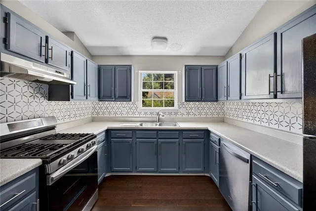 a kitchen with a sink stove and cabinets