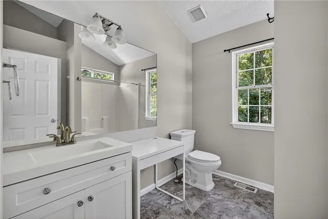 a bathroom with a sink toilet and window